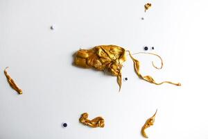 Gold slime and handmade details on white background photo