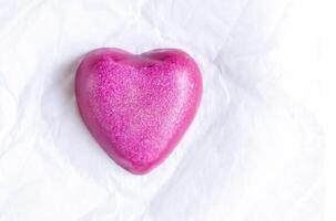 Heart shaped bar of soap on a light soft background. Top view. photo