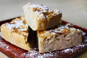 Homemade sweet apple pie with cinnamon and and powdered sugar. photo