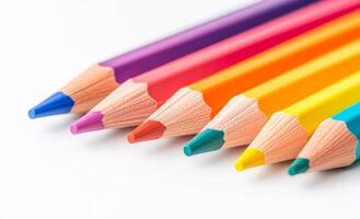 A row of colored pencils with a blue tip. The pencils are lined up in a row, with the blue pencil on the left and the red pencil on the right photo
