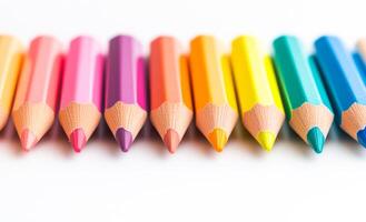 A row of colored pencils are lined up on a white background. The pencils are of different colors and sizes, creating a vibrant and lively scene. Concept of creativity and artistic expression photo