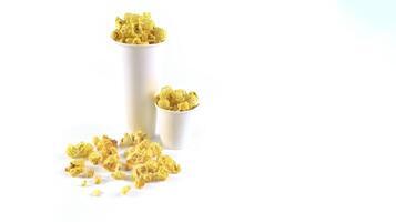 Isolated image of popcorn in a paper cup set against a white background, showcasing the fluffy, golden kernels spilling over the edges, perfect for themes related to snacks, cinema, or casual dining. photo