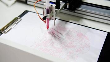 Robotic arm with a red pen is drawing a complex pattern on a white sheet of paper in slow motion. Minsk, Belarus - May 25, 2022 video