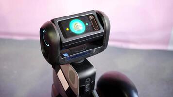 The robot's head slowly turns, and its display shows a screen with the owner addressing it. Minsk, Belarus - May 25, 2022 video