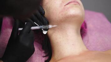 In a contemporary beauty salon, a woman is undergoing mesotherapy. She enjoys the treatment designed to maintain youthfulness and skin firmness, benefiting from professional cosmetic services video