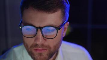 Trader investor broker in eyeglasses and formal wear working with pc while sitting in his office in front of computer screens with trading charts video