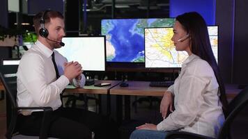 Two transport dispatchers sitting at desk in office monitoring cargo transportation and giving high five doing great job video