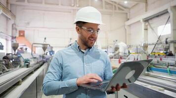 Industrial programmer checking the conveyor with laptop computer video