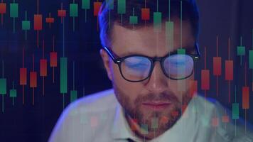 Cryptocurrency stock market trader wearing glasses looking at computer screen with trading charts reflecting in eyeglasses watching stock trading market financial data growth concept video