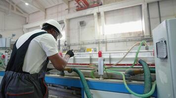 Black engineer in uniform with tablet checks the cooling system at the factory video