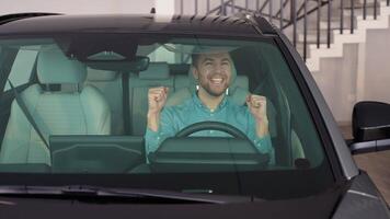 A handsome man rejoices in buying a new car video
