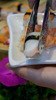 make sushi master sushi makes sushi rolls from nori rice, bell pepper and shrimp, preparing Japanese food with hands in gloves on table close-up. video