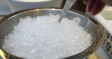 crushed ice for drinks Use a large ladle to scoop ice for drinks from an iron bowl at the buffet table video
