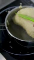 brew dough Process of creating brewed dough for eclairs or profiteroles. Confectioners hands in blue gloves mix all ingredients together in a cooking pan to create delicious brewed dough. video