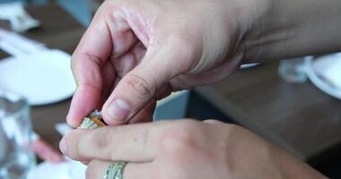 male hands open a shell, taking out a clam, showing how to open a shell correctly video