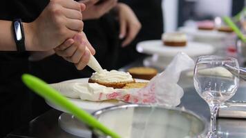Using a palette knife, decorate a bento cake with a flower made of cream. Selective focus. video