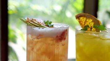 cold lemonade summer cocktails from guava and orange on the table near the window there are drinks with ice with a straw with dried fruits and mint video