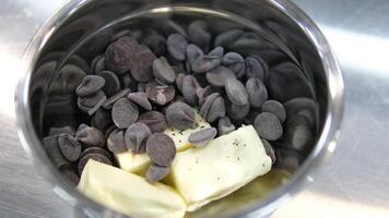 dark chocolate and butter on a plate. Pieces of cocoa butter are sprinkled on top of a plate of dark chocolate. Preparation of confectionery products. video