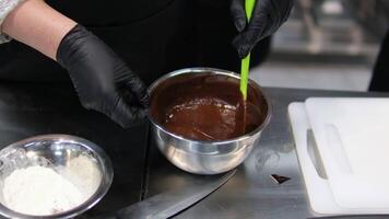 Lägg till mjöl till tomte smet steg förbi steg de bearbeta av framställning choklad kakor.kvinnas händer blanda ägg och Smör använder sig av en mixer. processer av förberedelse av choklad brownies närbild på de tabell. video