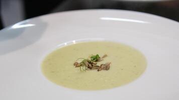 Close up view Spoon scoops up broccoli soup with sesame seeds on the surface. cream soup with seeds Delicious homemade creamy pumpkin soup with cream with sesame seeds and watercress. video