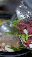 Hot pot is a traditional Chinese fire pot stew also known as steamboat dish in which a heat source is placed on the dining table. keeps a pot of broth on low heat video