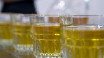 Apple juice is poured into glasses. Buffet table with juice, champagne and fruit. Drinks are poured into glasses. Glassware. video
