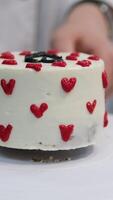 Using a palette knife, decorate a bento cake with a flower made of cream. Selective focus. video