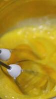 beat eggs with a hand mixer Dipping a switched on mixer into a metal bowl, for whipping eggs. video