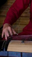 chinese musical instrument with strings. hand of man playing Guzheng.The guzheng or gu zheng, also simply called zheng, is a Chinese instrument video