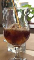 add ice to cola pour cola over ice cubes in glass on walnut table with space for text video