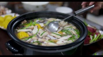 Hot pot is a traditional Chinese fire pot stew also known as steamboat dish in which a heat source is placed on the dining table. keeps a pot of broth on low heat video