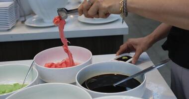 at the buffet table, collect ginger sauce and wasabi for sushi video