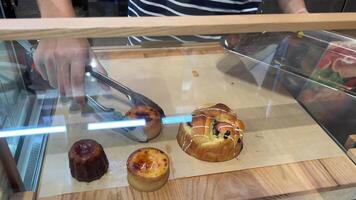 get dessert from the display case shop assistant waiter takes the dessert from the display case and puts the tasty treat on a plate to warm up video