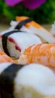 Sushi rolos dentro uma plástico caixa rodar fechar-se em Preto fundo. pronto para comer conjunto Sushi caixa com diferente delicioso japonês rolos dentro uma Entrega recipiente. conceito do Comida entrega, Leve embora Comida video
