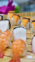 Set of delicious Japanese sushi rolls on stone black board. Top view. Chopsticks take sushi from set and dip it in soy sauce. Various types of sushi with red caviar, fish, Philly cheese and chopsticks video