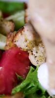 add sauce to salad. chef adds edible flowers to duck salad served on a deep white plate with dressing. video