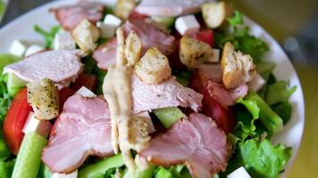 add sauce to salad cooking Caesar salad inside deep cooking bowl adding sliced cherry tomatoes video