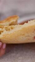 Pita bread lies in a basket on a table, hands from different sides pull towards it and tear off a piece. Lavash is traditional bread in Near East countries. Close-up video