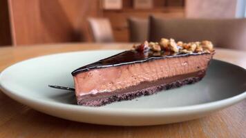 Chocolate dessert cheesecake on plate close-up. Cheesecake is a dessert made with a soft fresh cheese , typically cottage cheese, cream cheese, quark or ricotta, eggs, and sugar. It may have a crust video