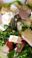 Caesar salad pick up salad with cheese pieces using a fork video