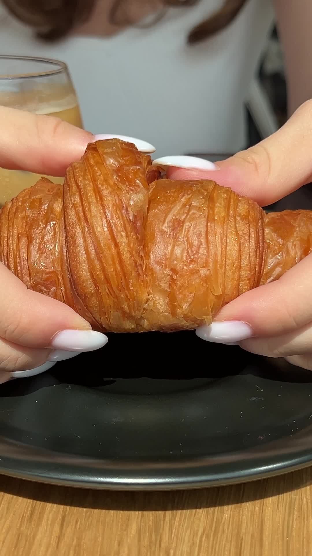 break croissant woman in cafe serving cappuccino with croissant.girl