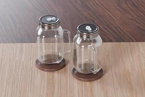 Transparent glass mug jar with stainless steel metal lid and handle placed on a wooden table. Suitable for branding your product with quality 3d rendering. Empty drinking glass, realistic mock-up photo