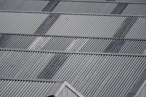 Monochrome view on industrial rooftop with geometric patterns created by the alignment of corrugated metal sheets. photo