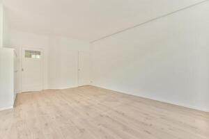 An empty room with white walls and wooden floors photo