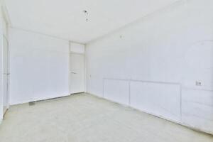 An empty room with white walls and a door photo