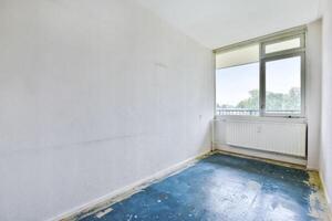 An empty room with a blue floor and a window photo