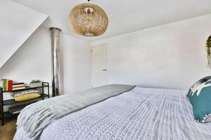 A bedroom with a bed, a lamp and a window photo