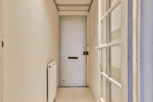 A narrow hallway with a door and a window photo