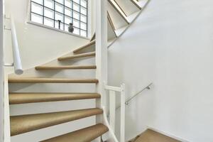A staircase with a white railing and a window photo