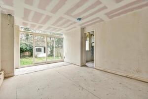 An empty room with a large window and a ceiling photo